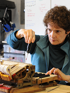 A woman is working on something in her hand.