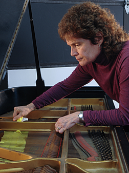 woman repairing grand piano