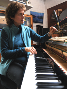 woman sitting and tuning the piano