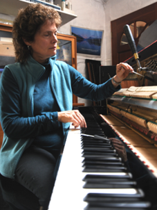 A woman sitting at the piano playing an instrument.